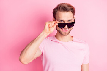 Photo of charming attractive young gentleman dressed casual t-shirt arm dark eyewear smiling isolated pink color background
