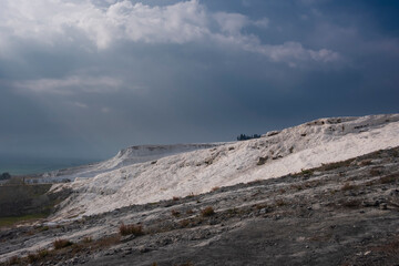 white cotton mountain Pamukkale, in turkey under a stormy sky