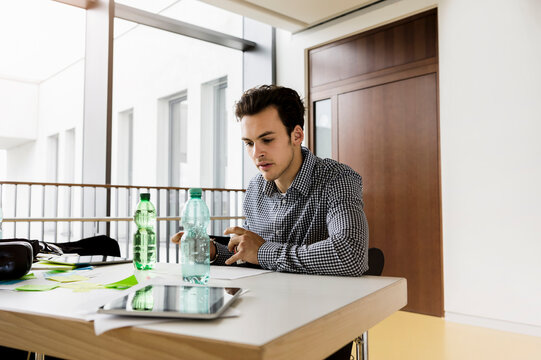 Germany, Bavaria, Munich, Young man working at desk
