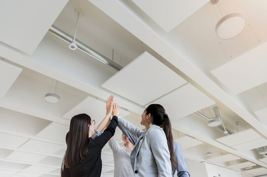 Germany, Bavaria, Munich, Business people doing high-five together in office
