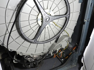 Disassembled washing machine. Washing machine with broken drive belt.
