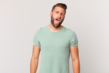 young handsome man with cheerful and rebellious attitude, joking and sticking tongue out
