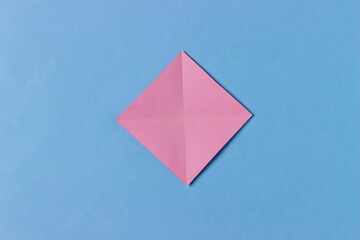 Step 2. Origami pig head. We fold opposite corners to each other so that we get two diagonal folds-lines.