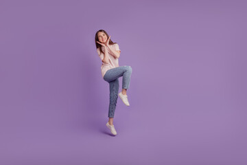 Fototapeta na wymiar Portrait of adorable tender girl jump girlish posing on purple wall
