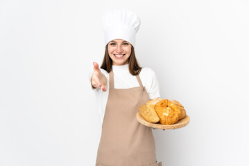 Young woman in chef uniform isolated on white background handshaking after good deal