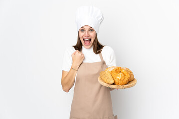 Young woman in chef uniform isolated on white background celebrating a victory