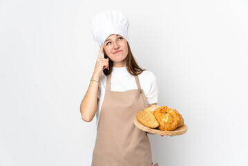 Young woman in chef uniform isolated on white background having doubts and with confuse face expression