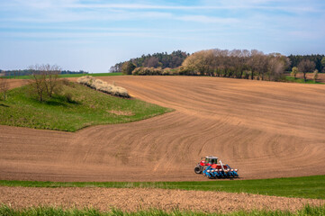 Fototapeta premium Landwirt beim bestellen der Felder im Frühjahr in Bayern