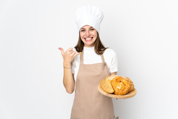 Young woman in chef uniform isolated on white background making phone gesture