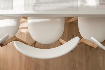 Top view of creamy white three chairs and white dining table with  beautifully filled sunshine in dining room