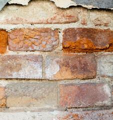 Closeup cracked concrete vintage brick wall.