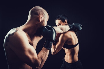 Plakat Shirtless Woman exercising with trainer at boxing and self defen