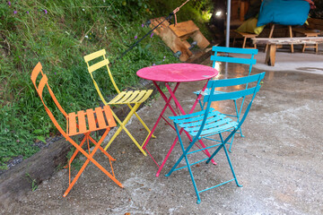 Mesa y sillas de metal de colores en la terraza vacía en el café día lluvioso en Asturias (España)