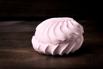 pink marshmallow on dark wood background copy space.