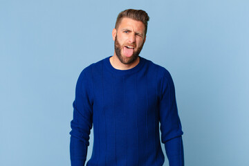 young handsome man with cheerful and rebellious attitude, joking and sticking tongue out