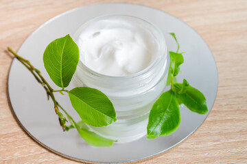 Ecologic concept. Hand made cream in glass boutle with green leaves. Zero waste products for personal care