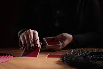 Soothsayer predicting future with cards at table indoors, closeup