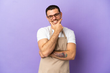Brazilian restaurant waiter over isolated purple background smiling