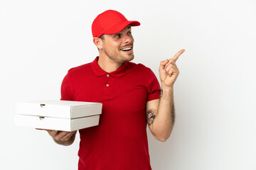 pizza delivery man with work uniform picking up pizza boxes over isolated  white wall intending to...