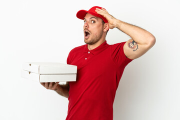 pizza delivery man with work uniform picking up pizza boxes over isolated  white wall doing...