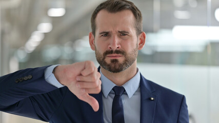 Portrait of Disappointed Middle Aged Businessman doing Thumbs Down 
