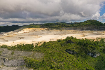 Fototapeta na wymiar Open pit limestone quarry in the mountains of Bohol Island, Philippines. limestone quarry view from above.