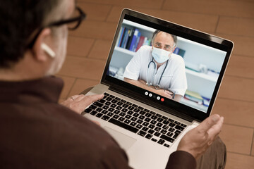 Fototapeta na wymiar Video chiamata tra un paziente e un medico curante attraverso un computer in contesto casalingo