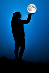Supermond in Hand Silhouette bei Nacht  leuchtender Mond auf Deich
