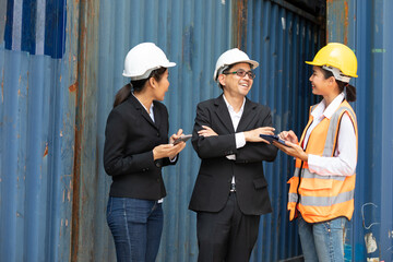 businessman and businesswoman talking with woman engineer in containers warehouse storage