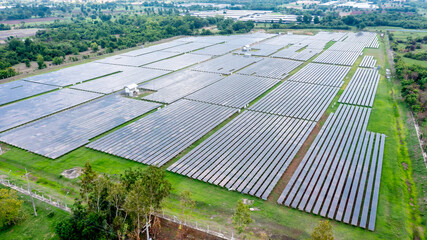 Aerial view of solar panels or solar cells on the roof in farm. Power plant with green field,...