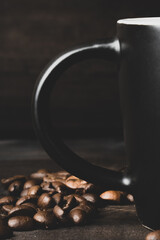 cup and grains of coffee on a dark woody background.