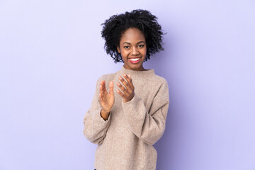 Young African American woman isolated on purple background applauding after presentation in a...