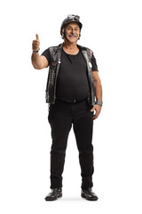 Full length portrait of a mature biker with a leather vest smiling and gesturing a thumb up sign