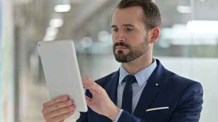 Portrait of Middle Aged Businessman using Digital Tablet