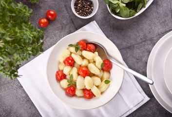 Homemade Italian gnocchi with tomato cherry on the wooden table