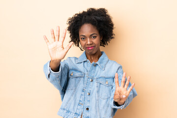Young African American woman isolated on beige background counting nine with fingers