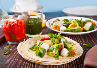 Homemade Indian naan flatbread with fresh salad and dips on the dinner table.