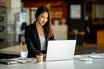 Portrait of Accounting businesswoman working on note laptop computer and analyzing real estate investment data, Financial and tax systems concept.