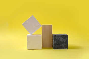 Mock up abstract minimal composition with geometric podiums for presentation. Trendy wood and stone pedestals, display blocks on yellow background. Advertising of spa, cosmetic, perfume products