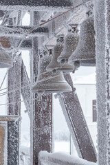 an iron bell covered with frost and snow on a frosty day on the top of Mount Belorie next to the Belogorsk monastery. Ural, Russia.