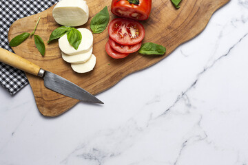 Homemade Italian caprese salad with sliced tomatoes, mozzarella cheese, basil and olive oil