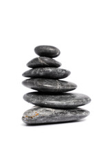 Zen stones or black pebbles stacked on top of each other like a pyramid, isolated on white background. Harmony, balance and meditation, spa, massage, relax concept.
