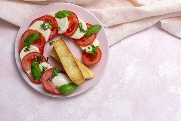 Homemade Italian caprese salad with sliced tomatoes, mozzarella cheese, basil and olive oil