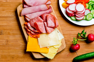Charcuterie platter. Assortment on cured and salted deli meats and cheeses, pastrami, salami,...