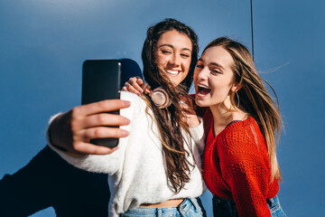 Couple of young girls taking a selfie with a cell phone