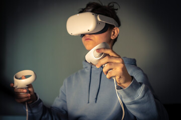 Teenager playing with virtual reality device. Cyberpunk futuristic mood, immersive experience with...
