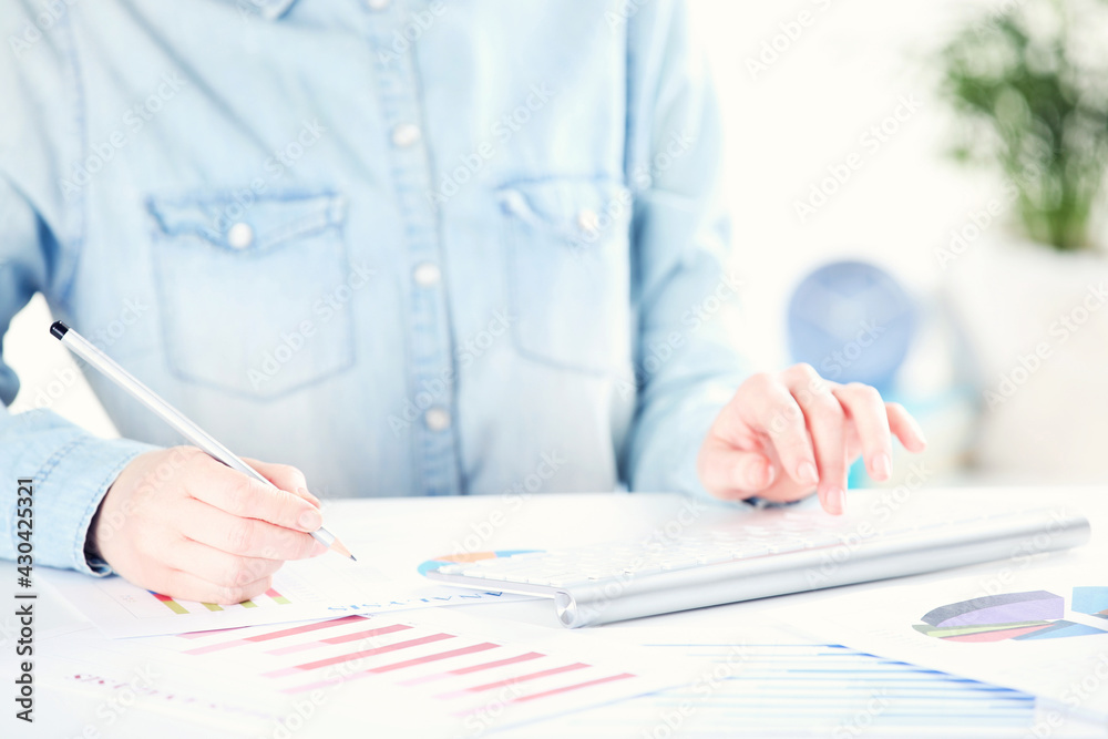 Poster female hands typing on computer keyboard and working with diagrams