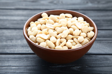 Peanuts in bowl on black wooden table