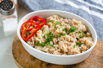 Cooked barley grains in a white bowl. Healthy food
