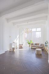 very light and bright interior of luxurious cozy living room with chic soft beige furniture with gold metallic elements, huge window to the floor and wooden parquet